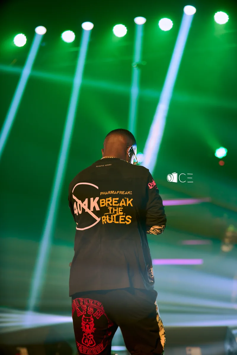 Performer on stage under green beams